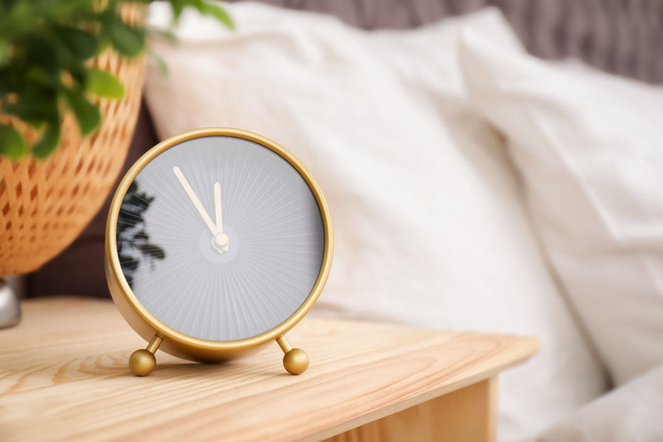 analog alarm clock on table near bedroom