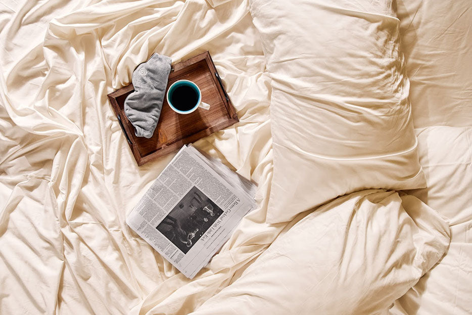 breakfast tray and newspaper on bed