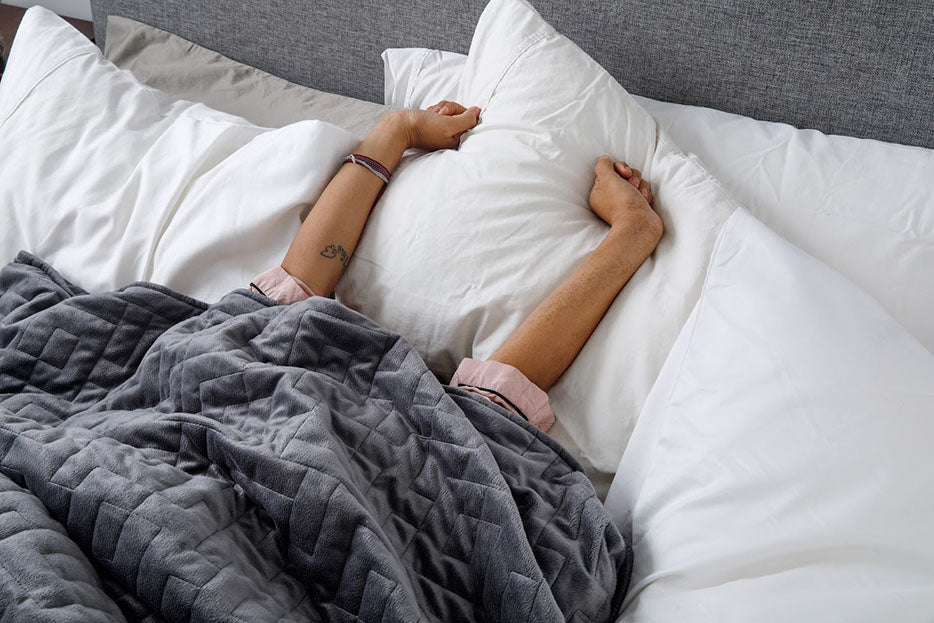 hands stretching out in bed