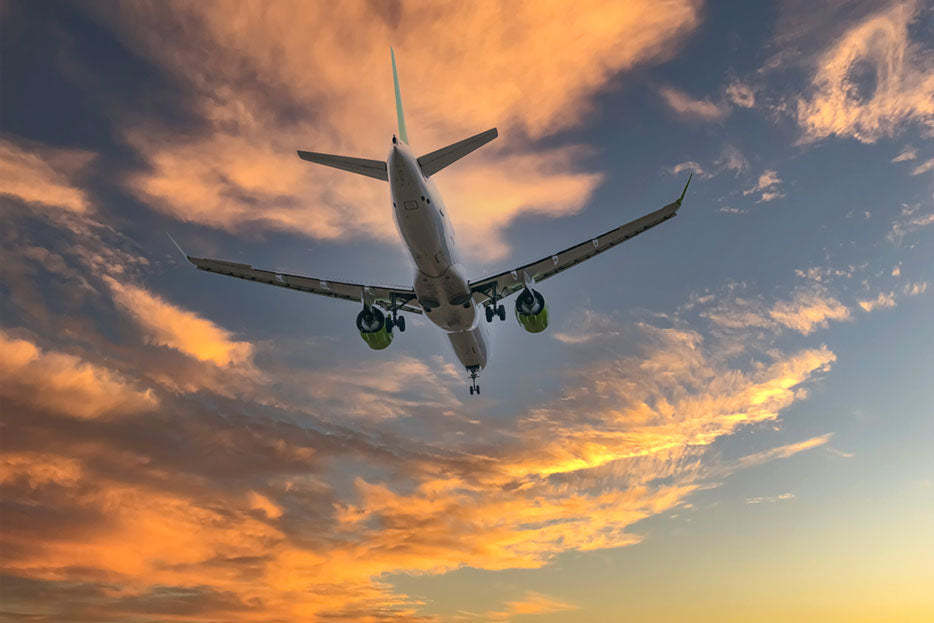 plane flying during sunset
