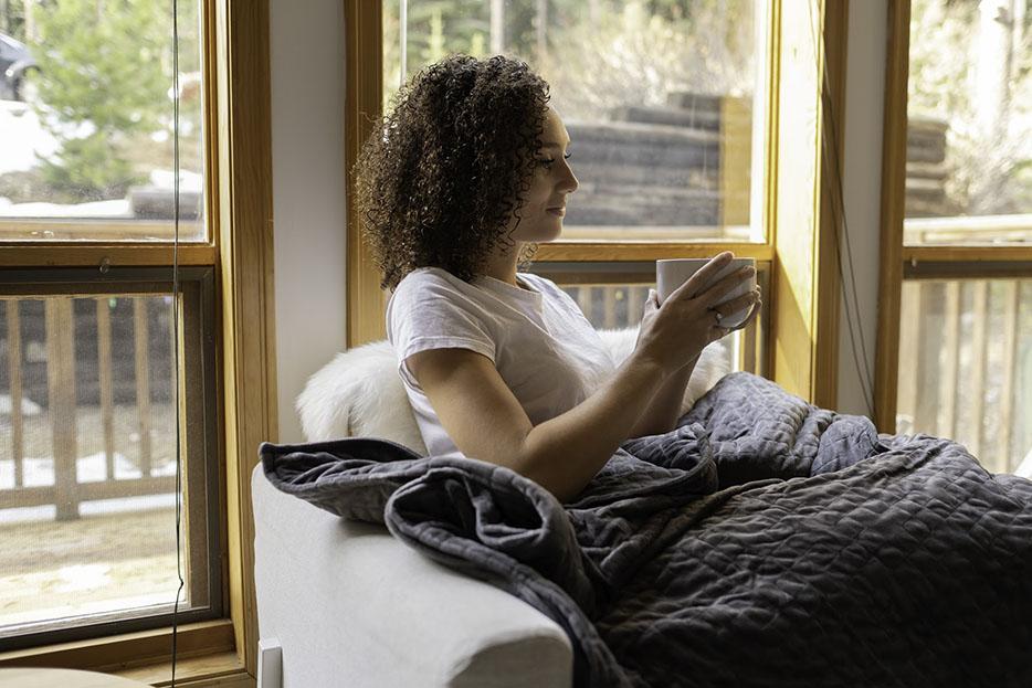 woman relaxing in a chair with a weighted blanket