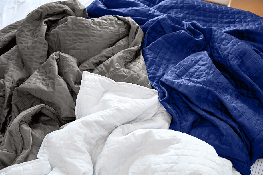 three weighted blankets in a pile