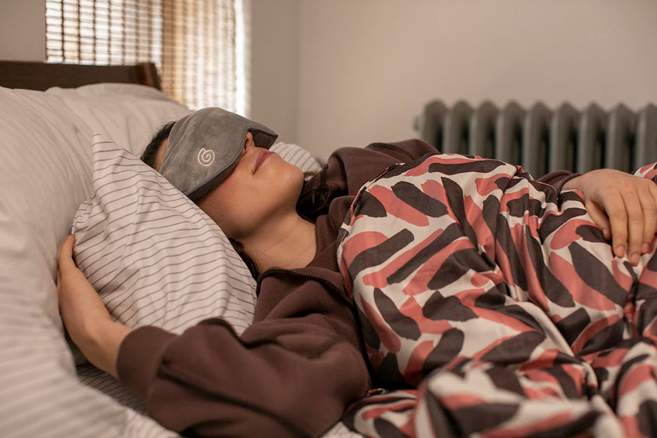 a woman sleeping while wearing a weighted mask