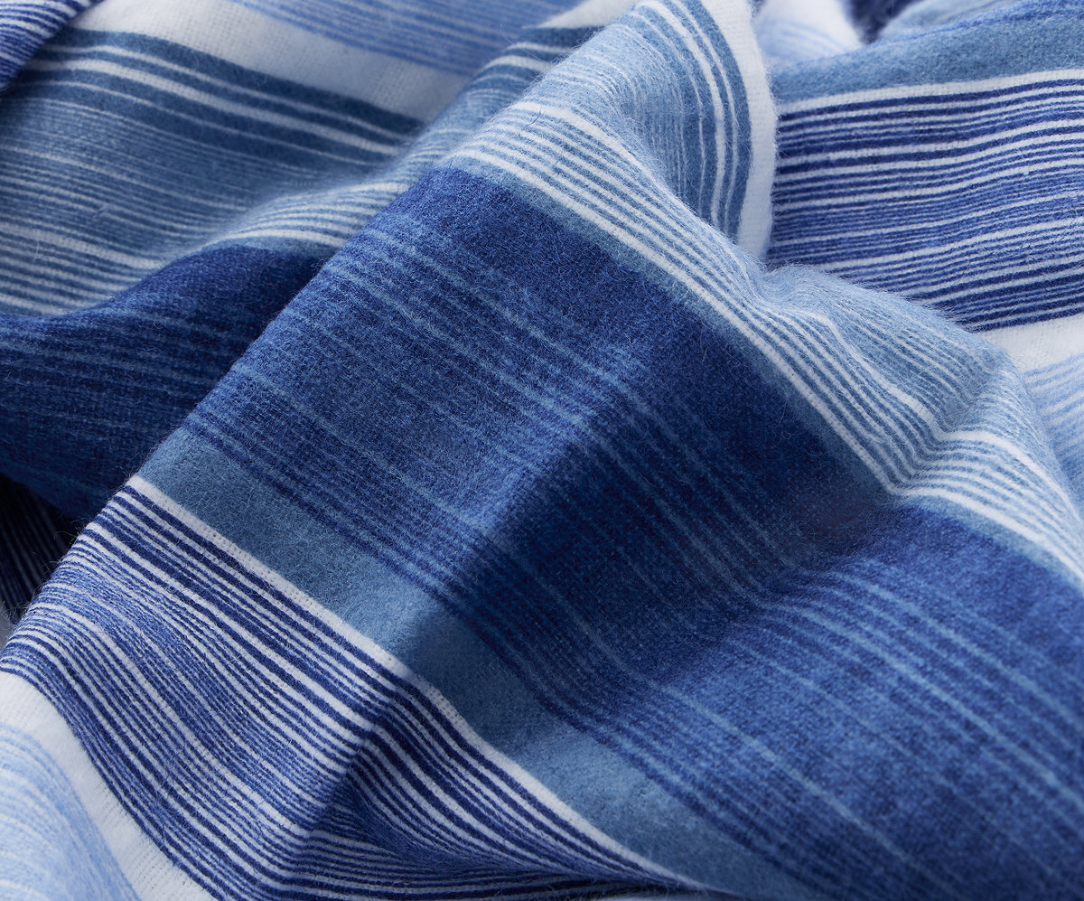 A close-up of blue striped gravity cotton flannel sheets