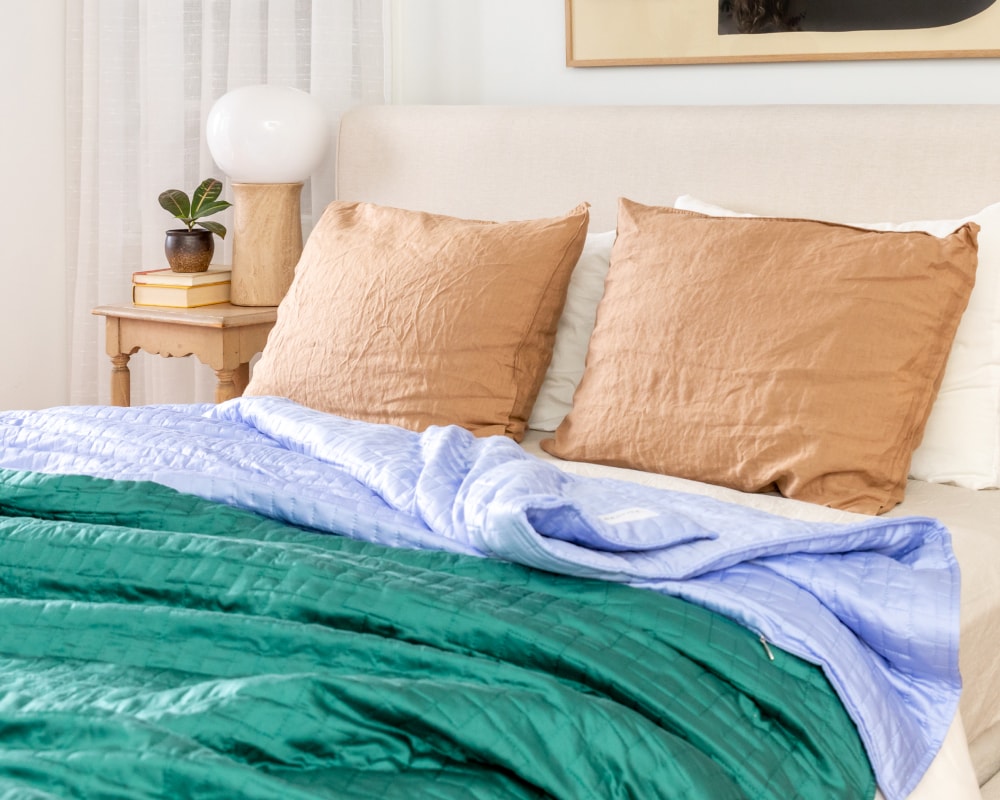 A couple Gravity Weighted Cooling Blankets laying on a bed - #color_forest-green