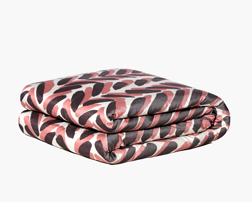 Pink and brown weighted blanket folded against a white background