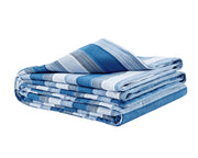 Blue striped flannel blanket folded against a white backdrop