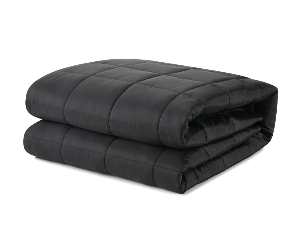 Black travel blanket with breathable technical fabric folded against a white backdrop #color_black