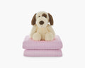 Light pink weighted blanket for kids folded with a plushie stacked on top