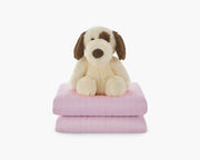 Light pink weighted blanket for kids folded with a plushie stacked on top