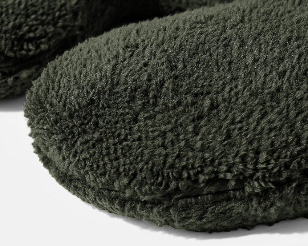 Closeup on the texture of a Black Gravity Weighted Neck Pillow on a white background - #color_black