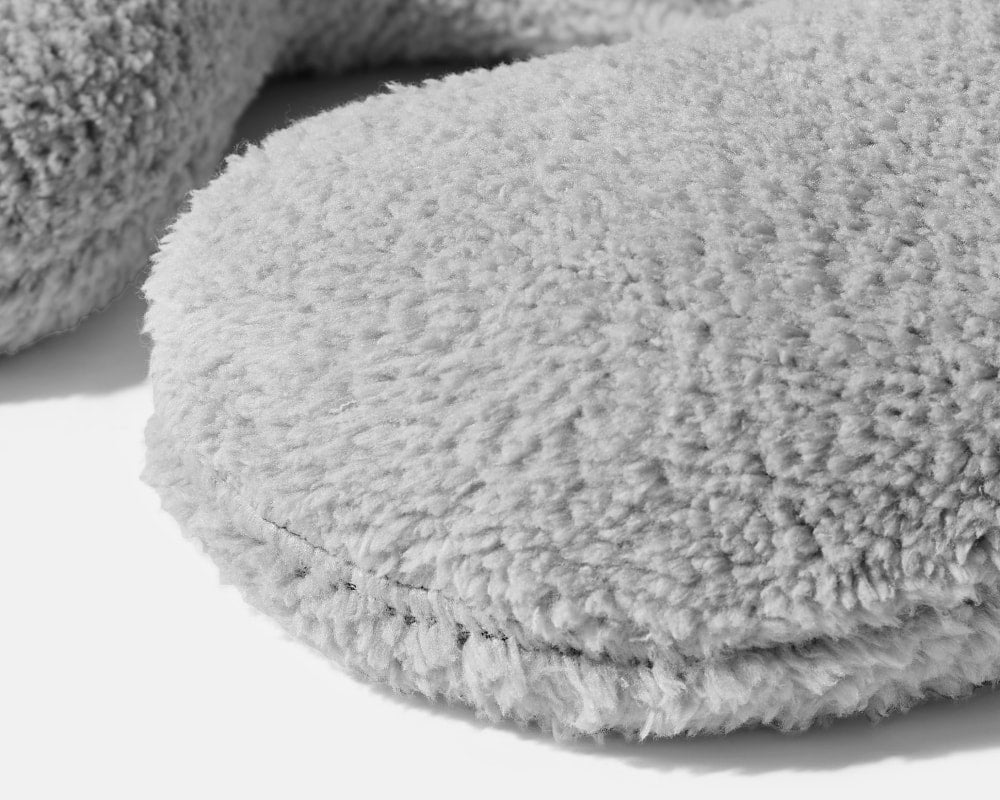 Closeup on the texture of a Light Grey Gravity Weighted Neck Pillow on a white background - #color_light-grey