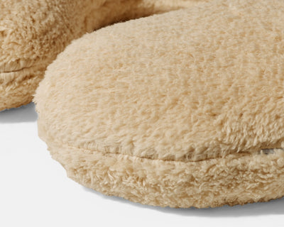 Closeup on the texture of a Tan Gravity Weighted Neck Pillow on a white background - #color_tan
