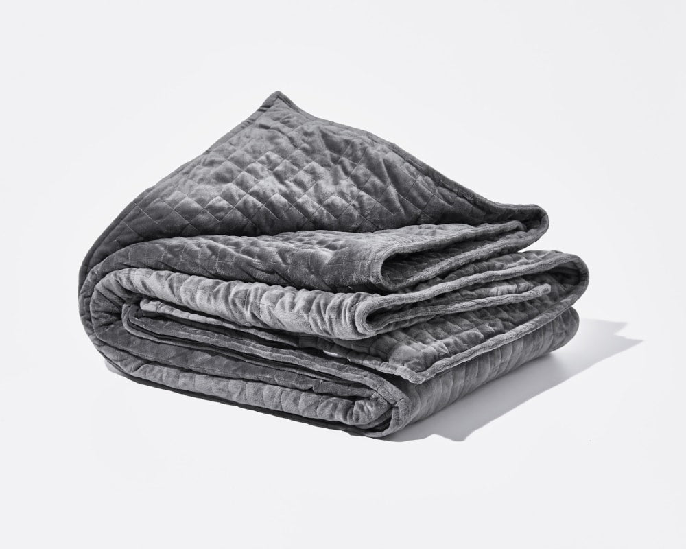 Original weighted blanket by Gravity in a plush grey fabric folded against a white backdrop - #color_grey