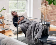 Man sleeping with a grey gravity weighted blanket 