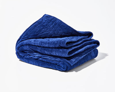 Original weighted blanket by Gravity in a plush navy fabric folded against a white backdrop - #color_navy