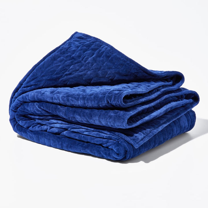 Original weighted blanket by Gravity in a plush navy fabric folded against a white backdrop - #color_navy