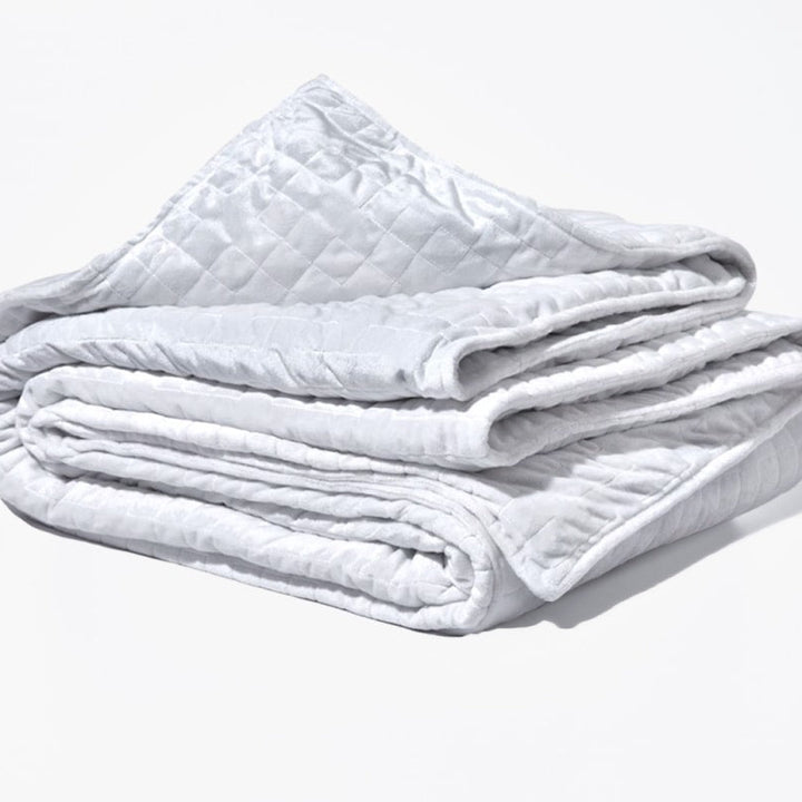 Original weighted blanket by Gravity in a plush white fabric folded against a white backdrop - #color_white