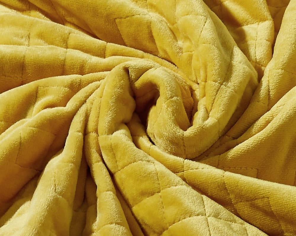 Original weighted blanket by Gravity in a plush gold fabric arranged in a spiral - #color_gold