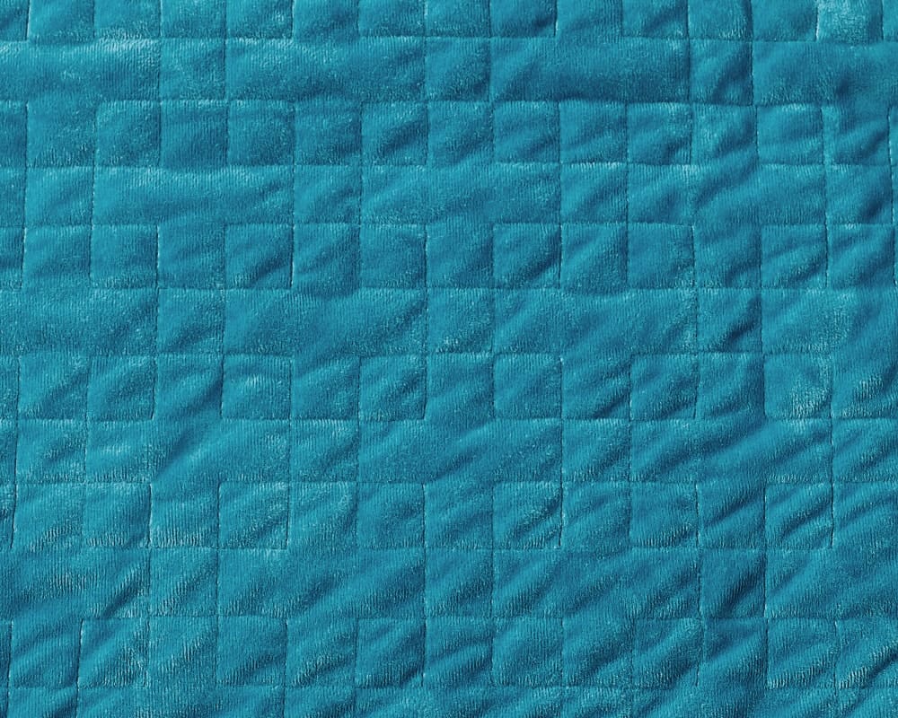 Closeup of stitching on plush teal fabric - #color_teal