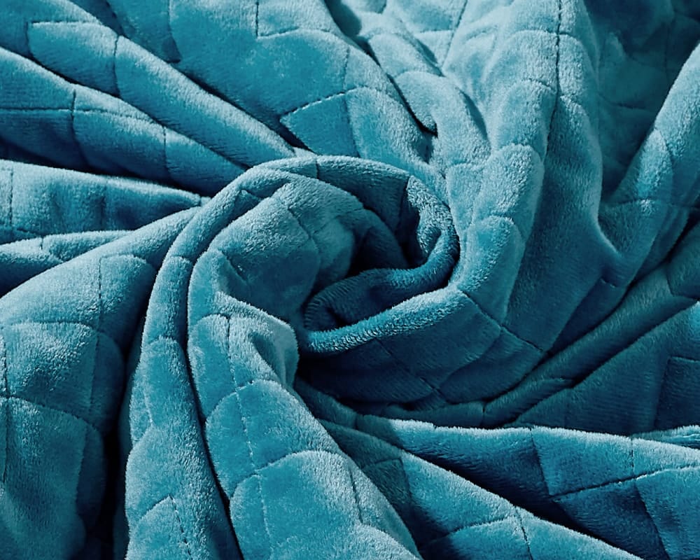 Original weighted blanket by Gravity in a plush gold fabric arranged in a spiral - #color_teal