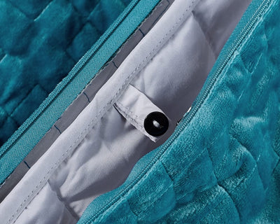 Original weighted blanket by Gravity in a plush teal fabric displaying its button fastener - #color_teal