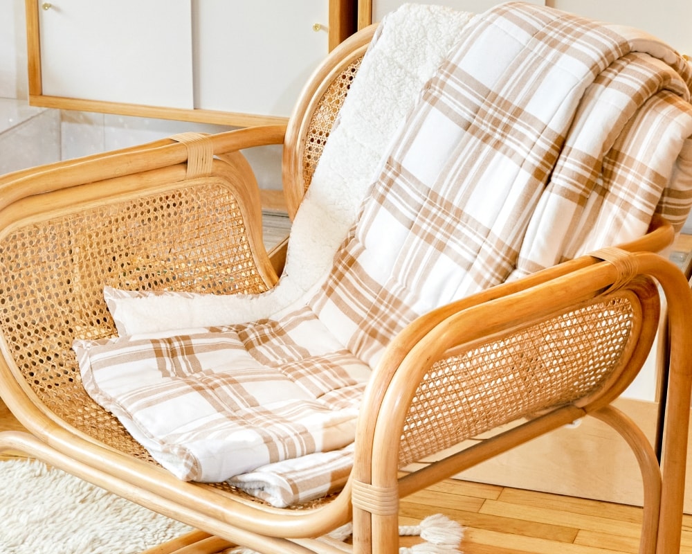 Taupe plaid flannel blanket draped over chair #color_taupe-plaid